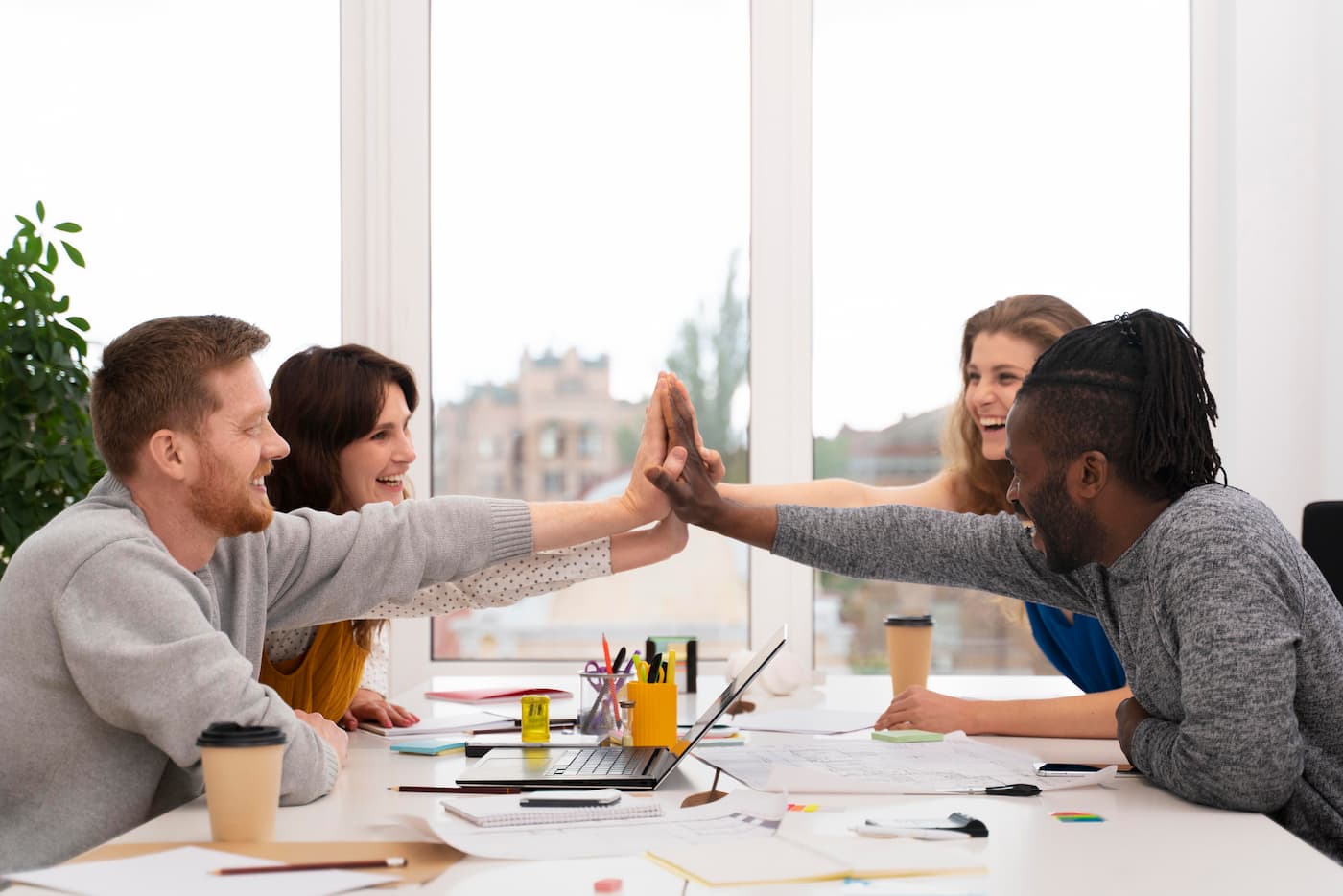 Trabajadores chocan las manos - Diferencia entre trabajo colaborativo y cooperativo